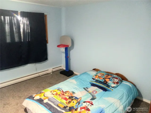 a bedroom with a bed and a dresser in it