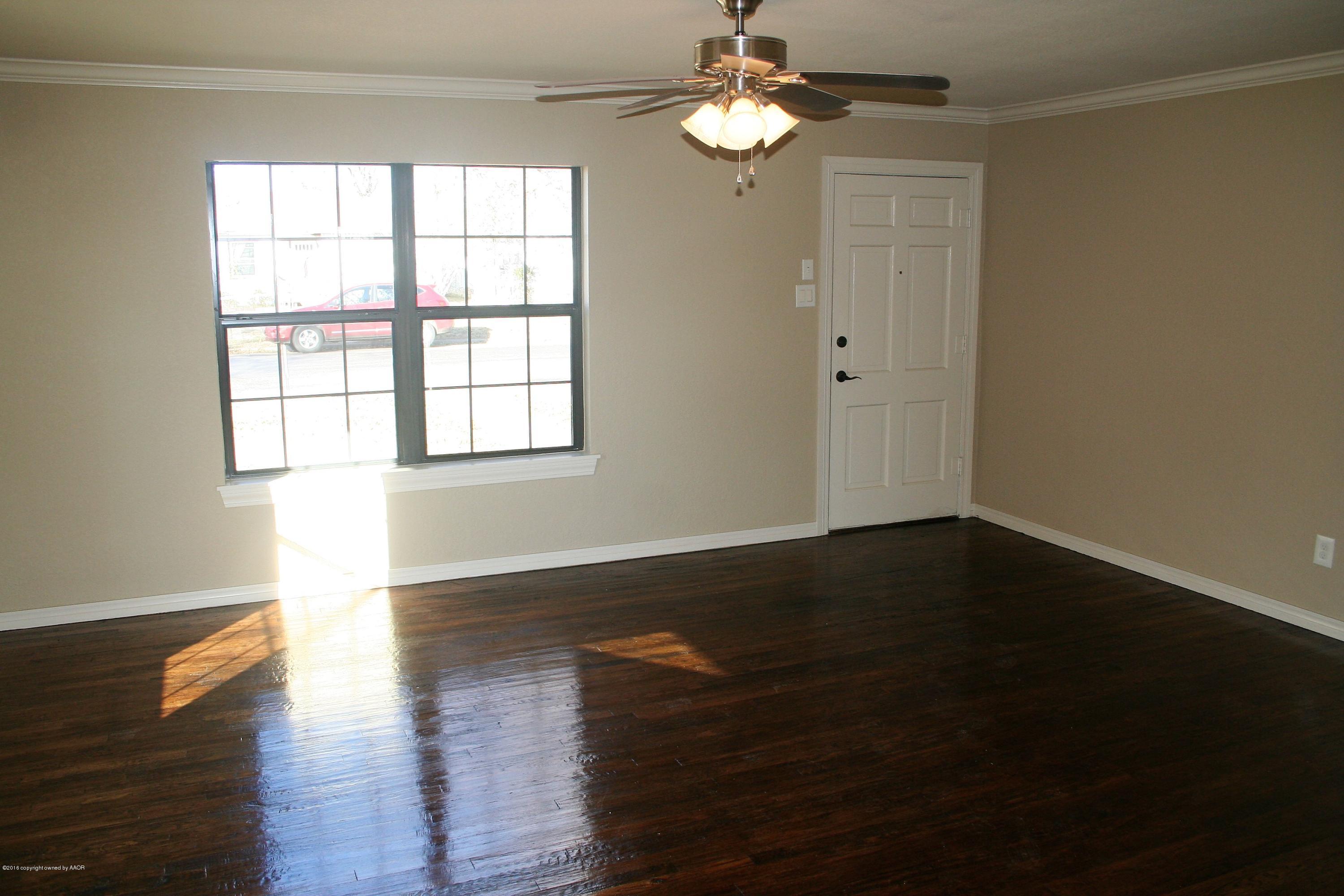 511 Southwest 45th Avenue Amarillo, TX 79110 - Photo 3 of 17 a view of an empty room with wooden floor and a window