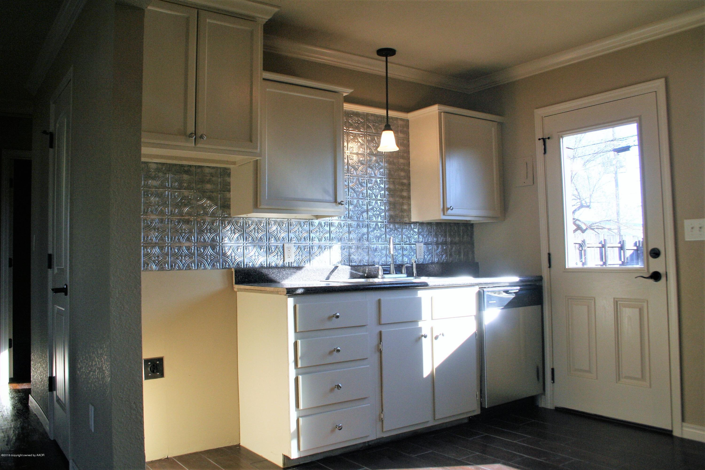 511 Southwest 45th Avenue Amarillo, TX 79110 - Photo 4 of 17 a kitchen with white cabinets and sink