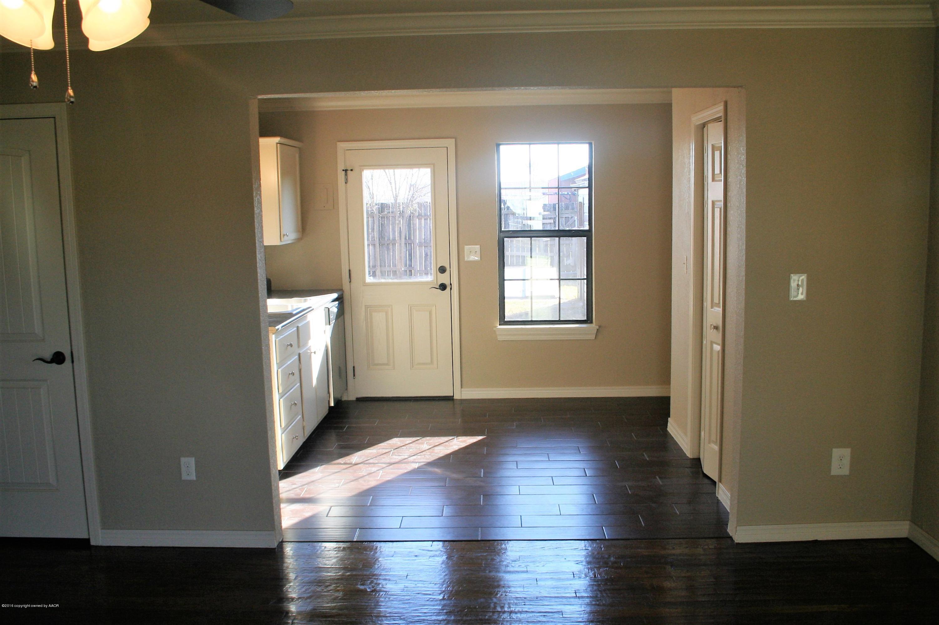 511 Southwest 45th Avenue Amarillo, TX 79110 - Photo 5 of 17 an empty room with wooden floor and windows