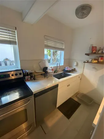 a kitchen with a stove cabinets and a window
