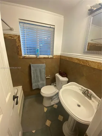 a bathroom with a sink a toilet and a mirror