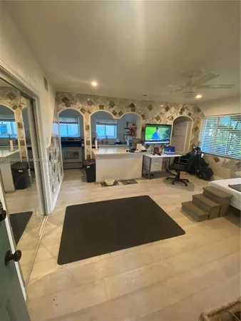 a living room with stainless steel appliances furniture a rug and a view of kitchen