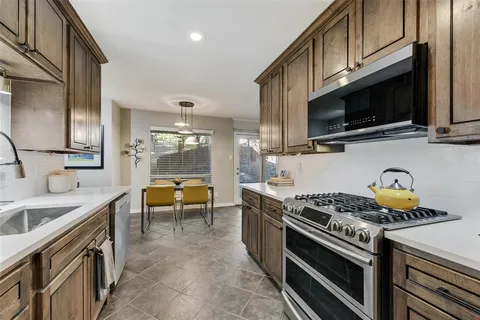 a kitchen with stainless steel appliances a stove a sink and a microwave