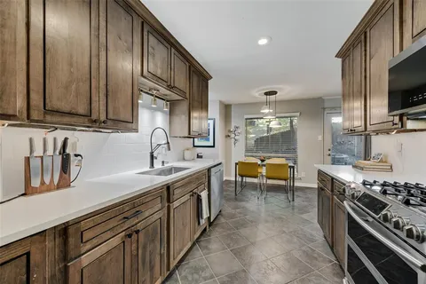 a kitchen with stainless steel appliances granite countertop a sink and a stove