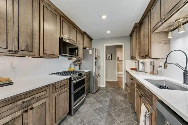 a kitchen with stainless steel appliances granite countertop a sink stove and refrigerator