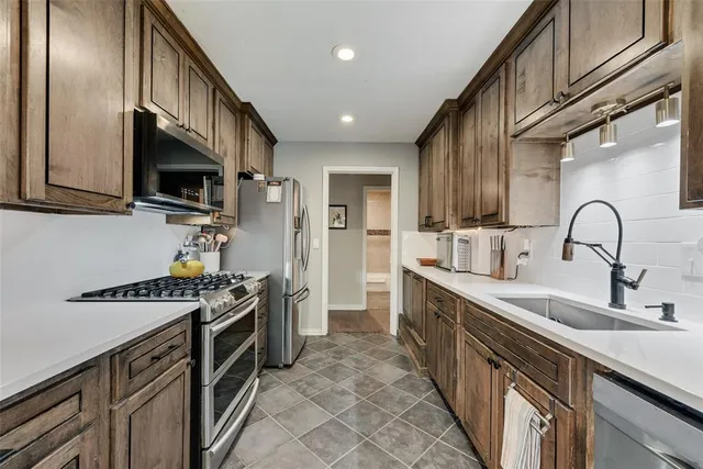 a kitchen with stainless steel appliances granite countertop a sink stove and cabinets