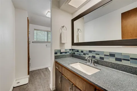 a bathroom with a granite countertop sink and a mirror