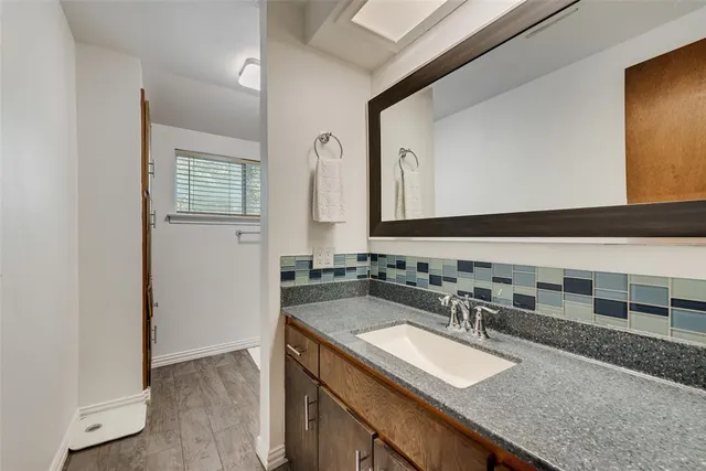 a bathroom with a granite countertop sink and a mirror