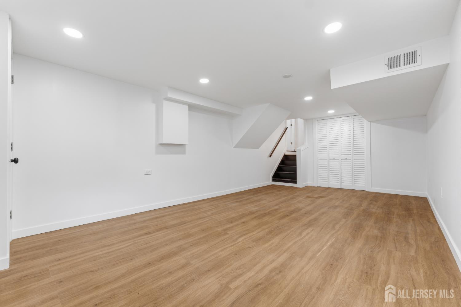 12 Daniel Road Spotswood, NJ 08884 - Photo 21 of 27 an empty room with wooden floor and hallway