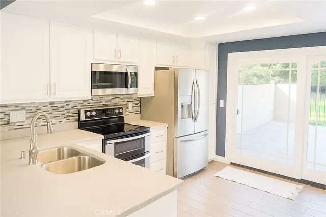 a kitchen with stainless steel appliances a stove a sink a microwave and refrigerator