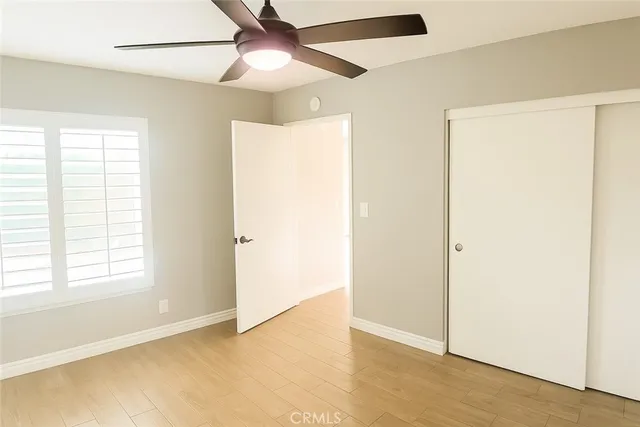 an empty room with fan and windows