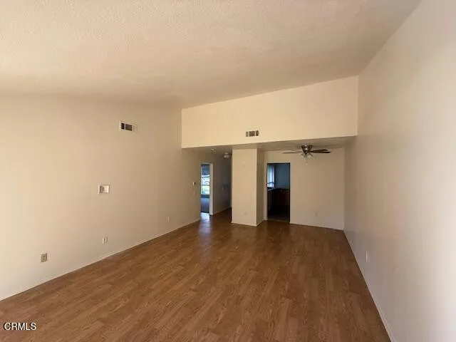 a view of an empty room with wooden floor