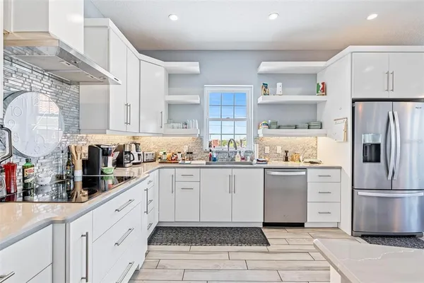 a kitchen with white cabinets and white appliances