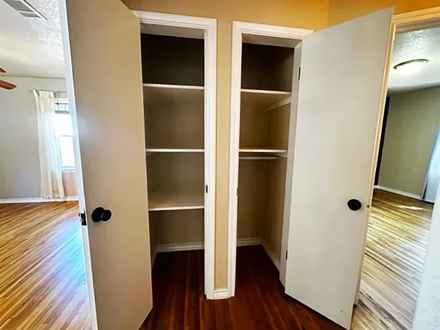 a view of walk in closet with wooden floor