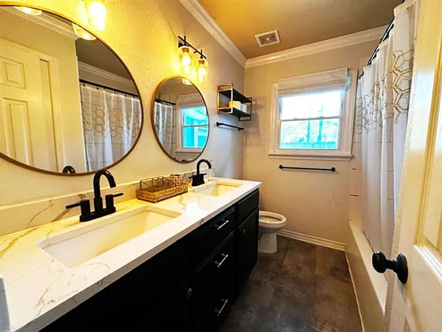 a bathroom with a double vanity sink mirror and toilet