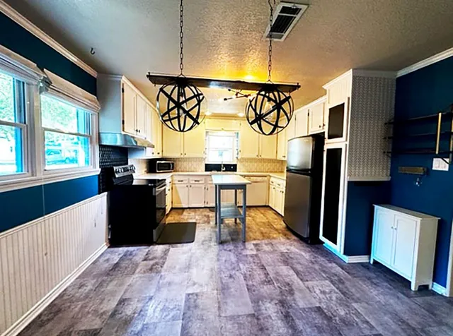 a kitchen with stainless steel appliances granite countertop a refrigerator a stove top oven a sink and dishwasher