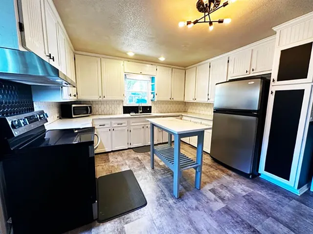 a kitchen with stainless steel appliances a refrigerator stove microwave and sink