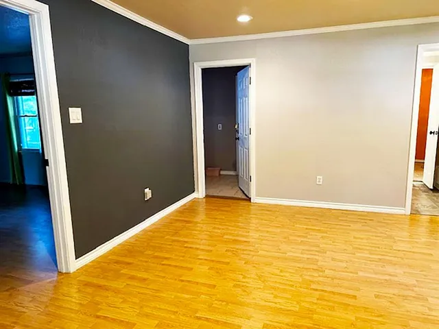 a view of an empty room with wooden floor