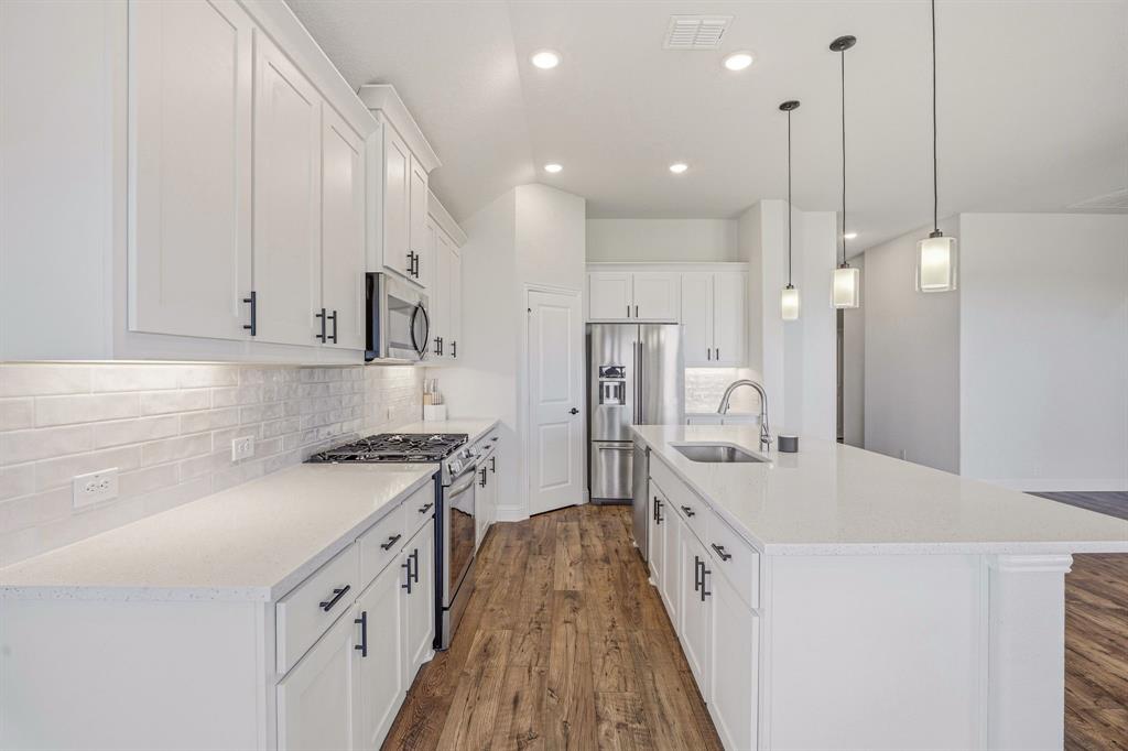 800 Jaguar Ridge Godley, TX 76044 - Photo 6 of 23 a large kitchen with stainless steel appliances lots of counter space and wooden floor