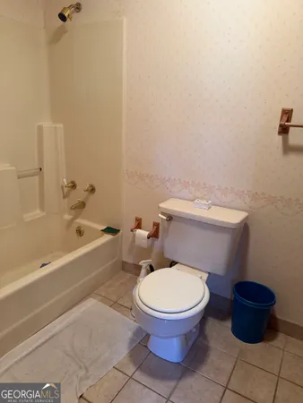 a white toilet sitting next to a bath tub