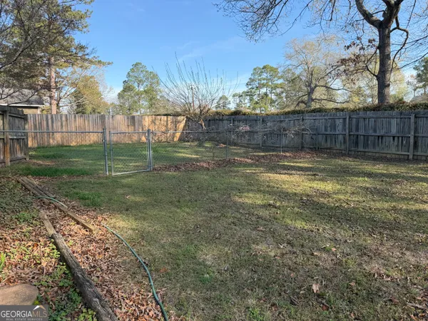a view of a backyard with wooden fence