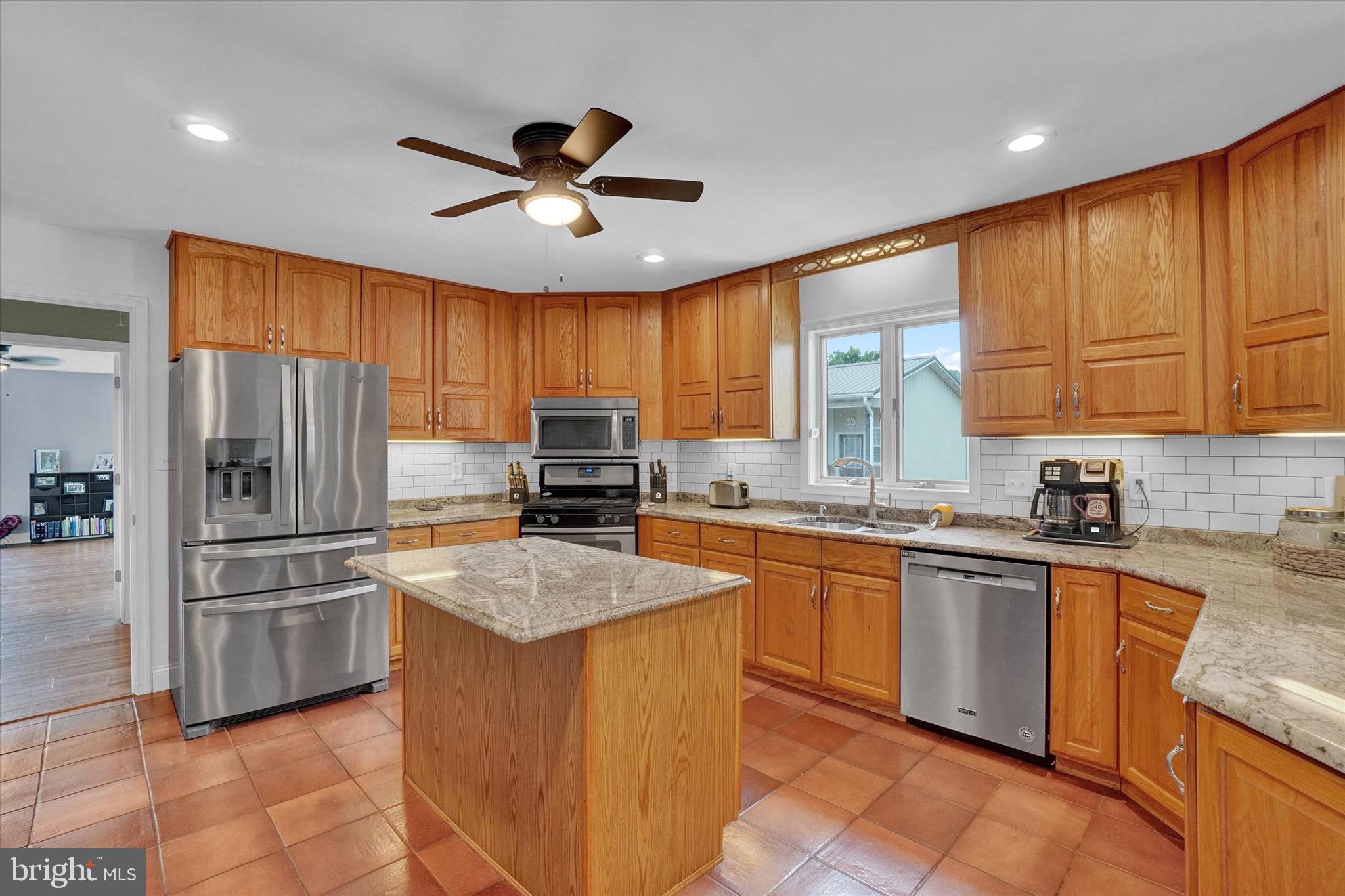 361 Bald Eagle Road Fawn Grove, PA 17321 - Photo 3 of 36 a kitchen with stainless steel appliances granite countertop a refrigerator a sink a stove a oven a dining table and chairs with wooden floor