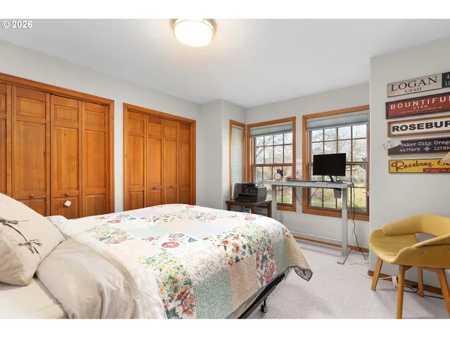 a spacious bedroom with a bed a table and chairs