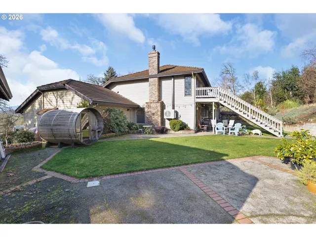 a view of a house with a big yard and large trees