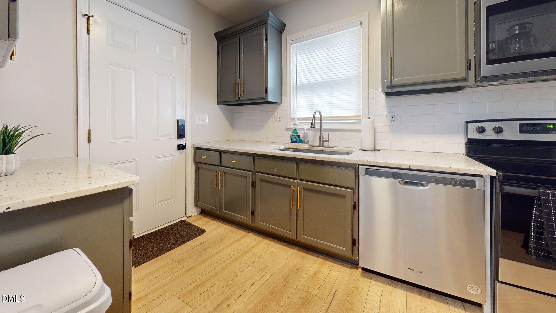 7720 Foxwood Drive Raleigh, NC 27615 - Photo 8 of 46 a kitchen with a sink cabinets and a wooden floor