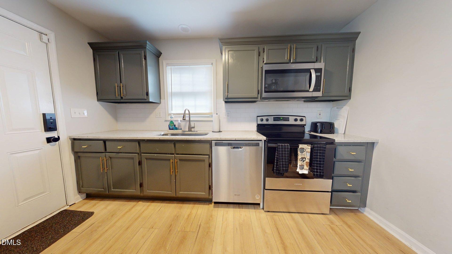 7720 Foxwood Drive Raleigh, NC 27615 - Photo 10 of 46 a kitchen with stainless steel appliances granite countertop a stove a sink and a microwave
