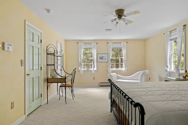 a spacious bedroom with a bed chandelier and a window