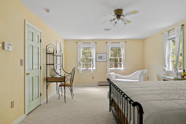 a spacious bedroom with a bed chandelier and a window
