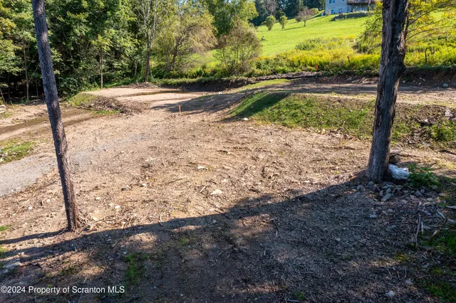 a view of a yard with wooden fence