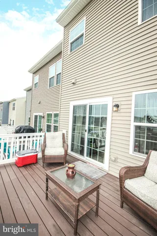 a view of a deck with couches and table and chairs with wooden floor
