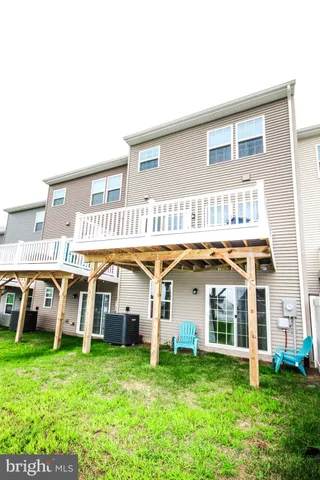 a view of a white house with a big yard and large trees