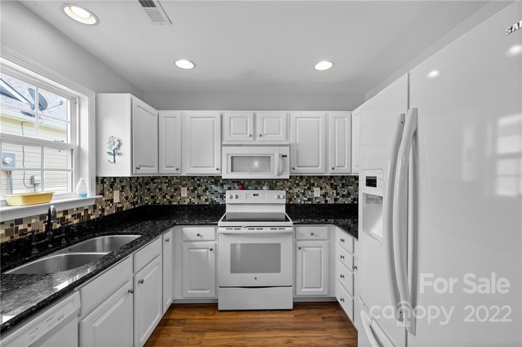 198 Lumber River Road Fletcher, NC 28732 - Photo 16 of 39 a kitchen with white cabinets and white appliances