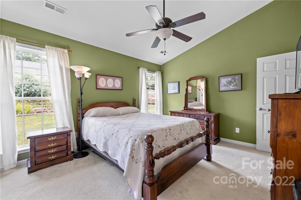 198 Lumber River Road Fletcher, NC 28732 - Photo 20 of 39 a spacious bedroom with a bed and a chandelier