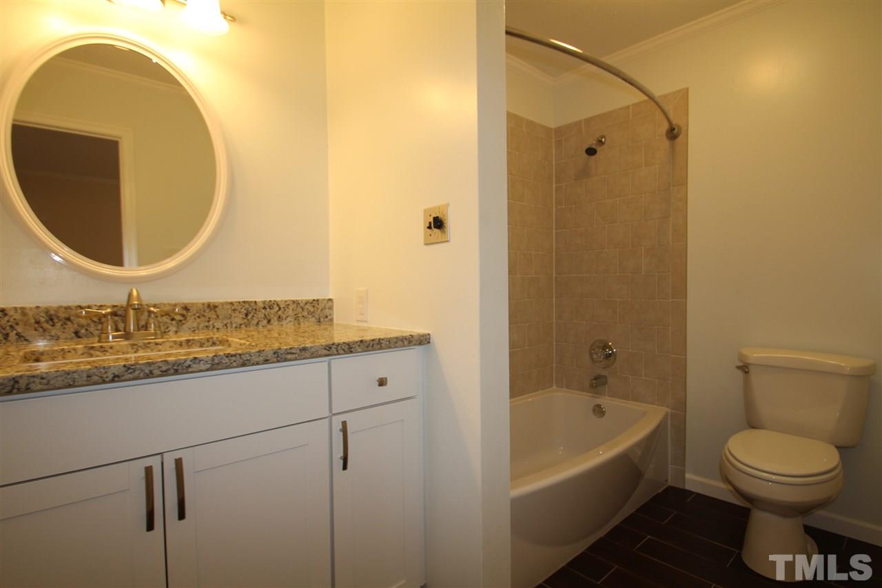 907 Torredge Road Durham, NC 27712 - Photo 12 of 19 a bathroom with a granite countertop toilet sink and mirror
