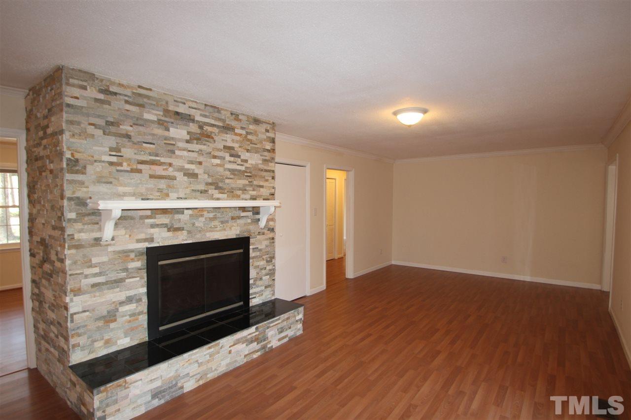 907 Torredge Road Durham, NC 27712 - Photo 4 of 19 a view of an empty room with wooden floor fireplace and a window