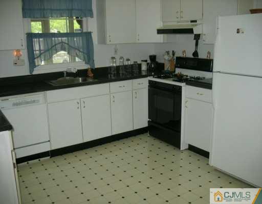 13 Sweetbriar Road Somerset, NJ 08873 - Photo 5 of 8 a kitchen with a sink a stove and cabinets