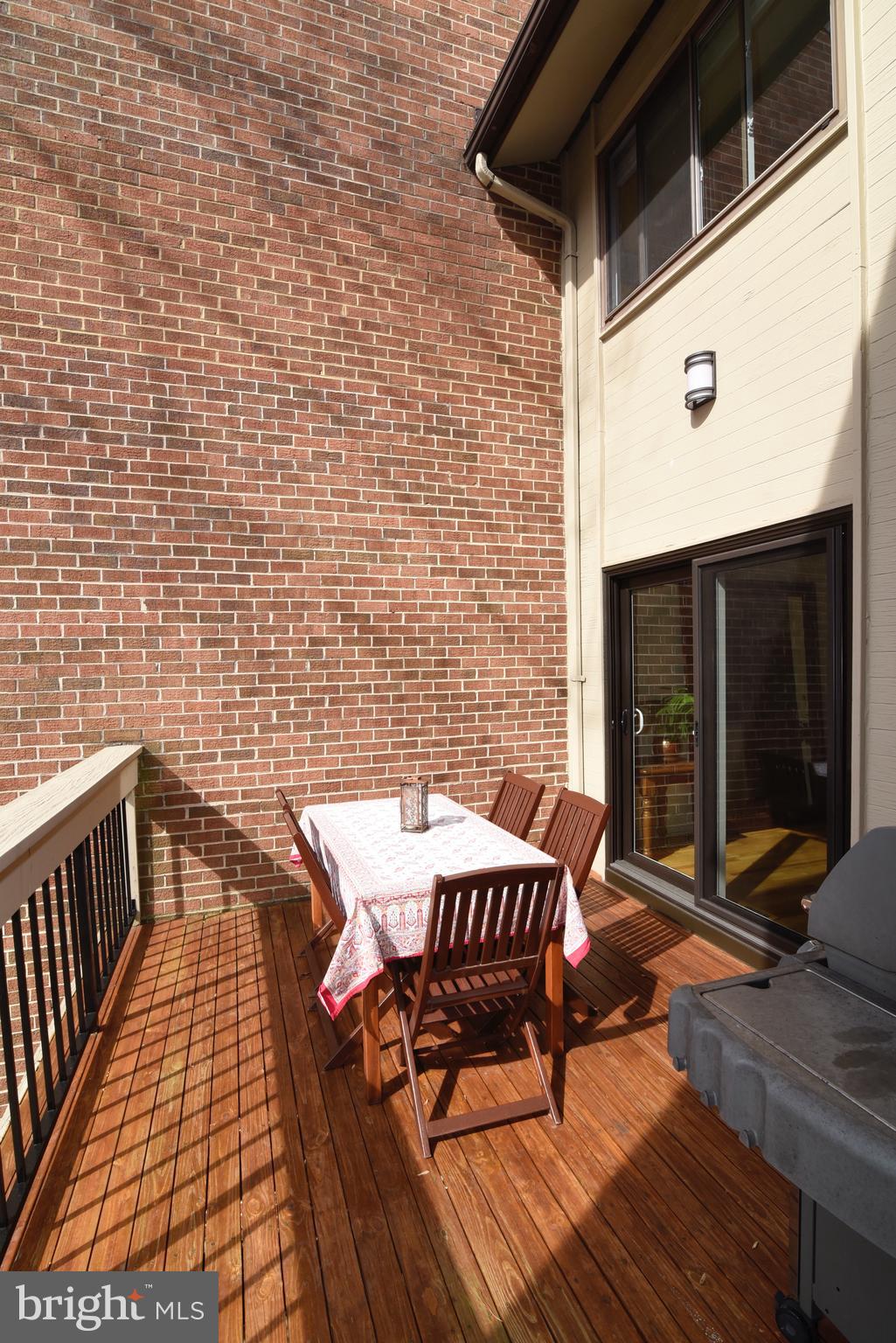 11749 Indian Ridge Road Reston, VA 20191 - Photo 13 of 53 a view of a patio with table and chairs with wooden floor and fence