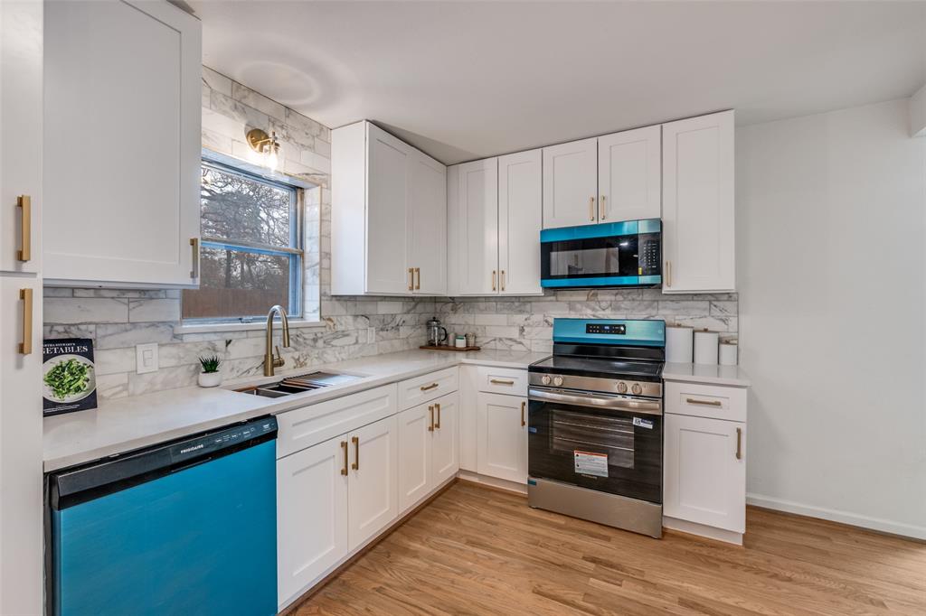 624 Forest Lane Hurst, TX 76053 - Photo 11 of 25 Kitchen featuring stainless steel appliances, white cabinets, light wood-style flooring, and light stone counters