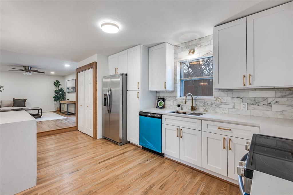 624 Forest Lane Hurst, TX 76053 - Photo 12 of 25 Kitchen with electric range, stainless steel fridge, white cabinets, ceiling fan, and light wood-style flooring