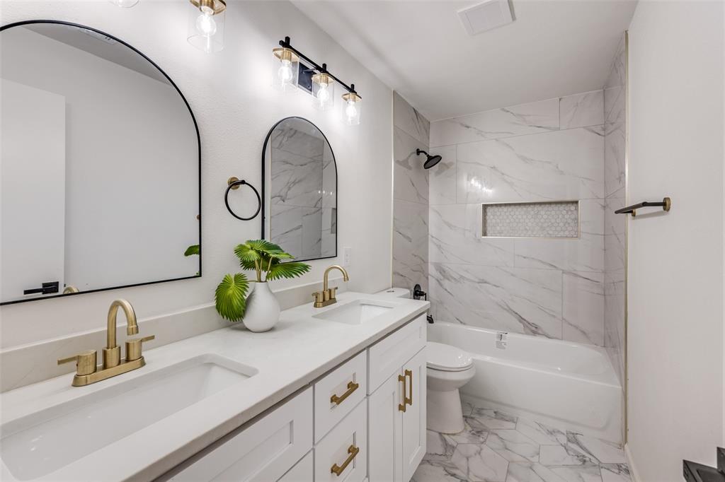 624 Forest Lane Hurst, TX 76053 - Photo 17 of 25 Full bath with shower / washtub combination, double vanity, and light marble finish flooring
