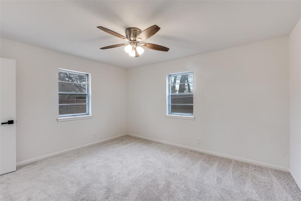 624 Forest Lane Hurst, TX 76053 - Photo 18 of 25 Unfurnished room with light carpet, healthy amount of natural light, and ceiling fan