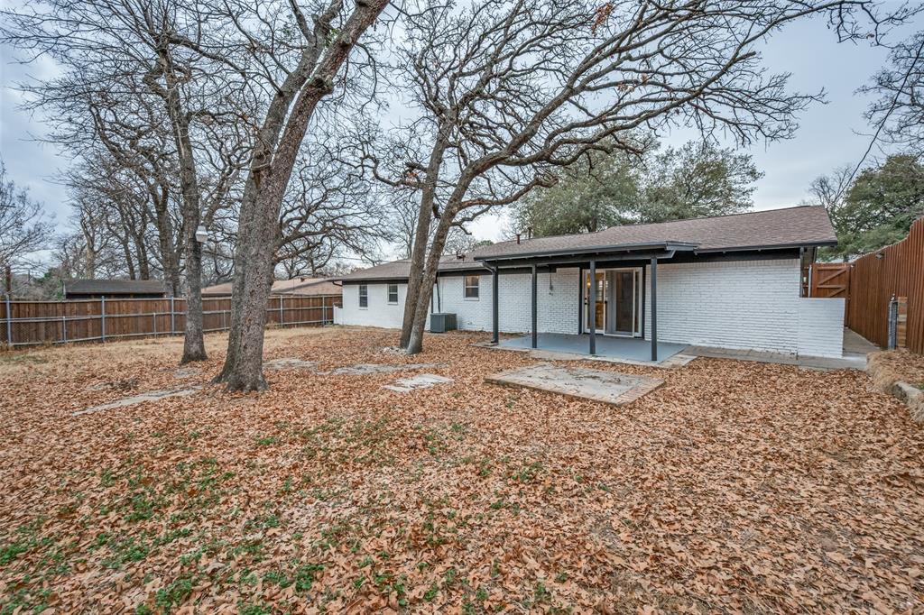 624 Forest Lane Hurst, TX 76053 - Photo 25 of 25 Back of property with a patio, brick siding, a fenced backyard, and roof with shingles