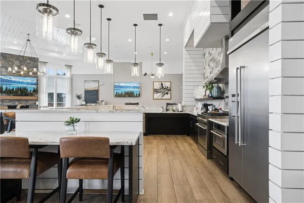 a kitchen with stainless steel appliances kitchen island granite countertop a sink stove and refrigerator