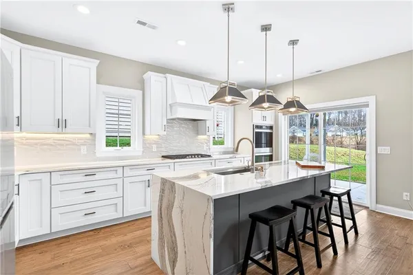 a kitchen with a stove a window and chairs