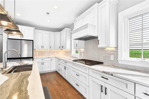 a kitchen with granite countertop a stove sink and cabinets